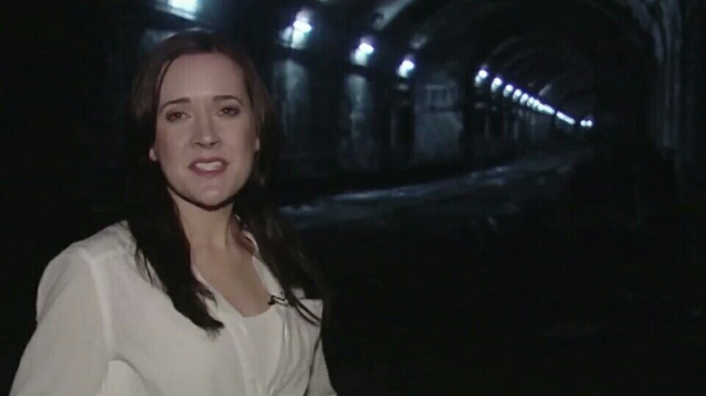 Bel Deliá as Natasha Warner in The Tunnel, presenting to the camera with the long, dark tunnel in the background.
