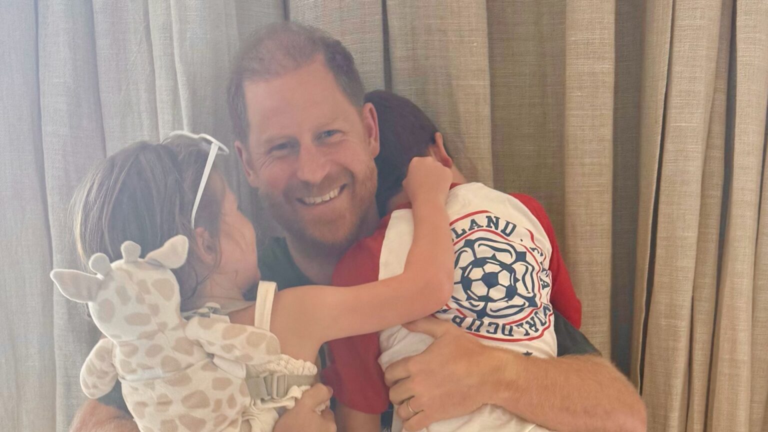 Prince Archie and Princess Lilibet hugging Prince Harry