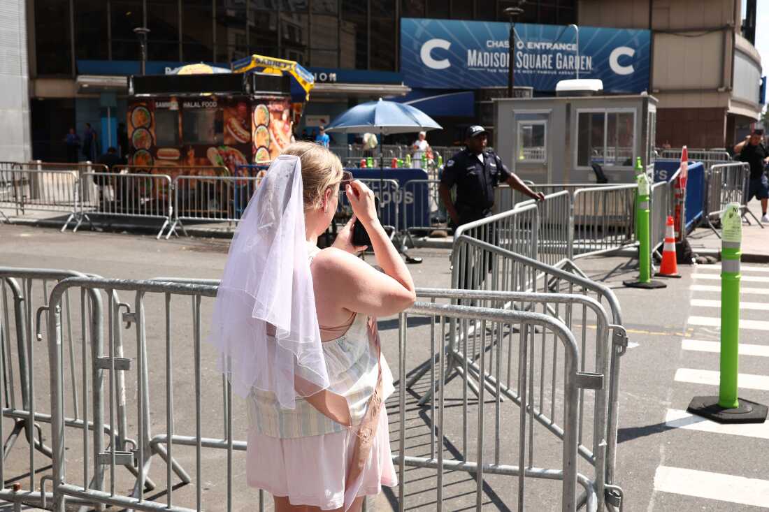 A woman wearing a white veil stands outside Madison Square Garden in New York City on July 3, 2026. Taylor Swift and Travis Kelce's official wedding plans are tightly under wraps, but New York is bracing to host the celebrity marriage of the year.