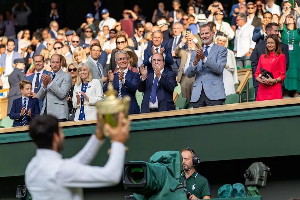 Carlos Alcaraz of Spain with the winners trophy is applauded by King Felipe of Spain during the Wimbledon Championships in July 2023.Credit: Tim Clayton/Corbis via Getty