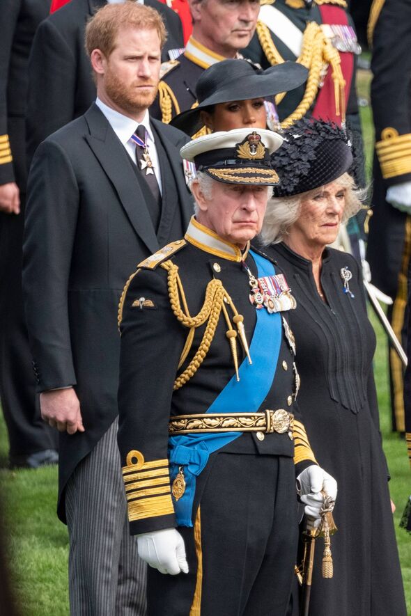 An individual in formal attire, standing among other formally dressed individuals, appears to be participating in a ceremonial e