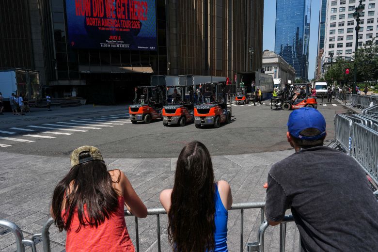 People watch as trucks are unloaded at Madison Square Garden on Wednesday.