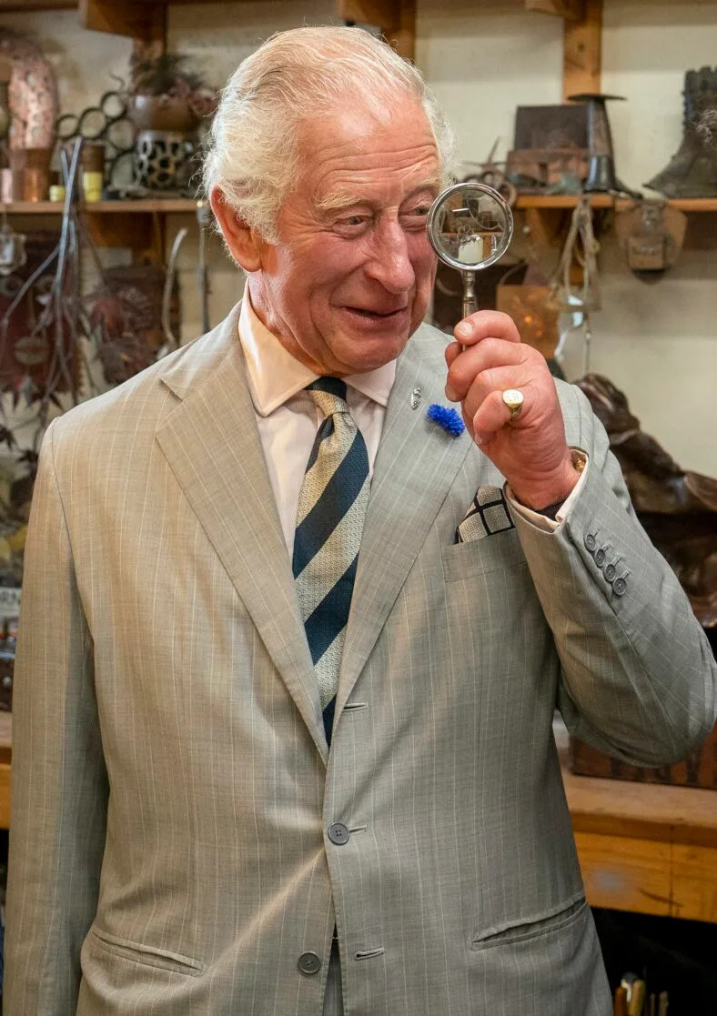 Prince Charles holds up a magnifying glass