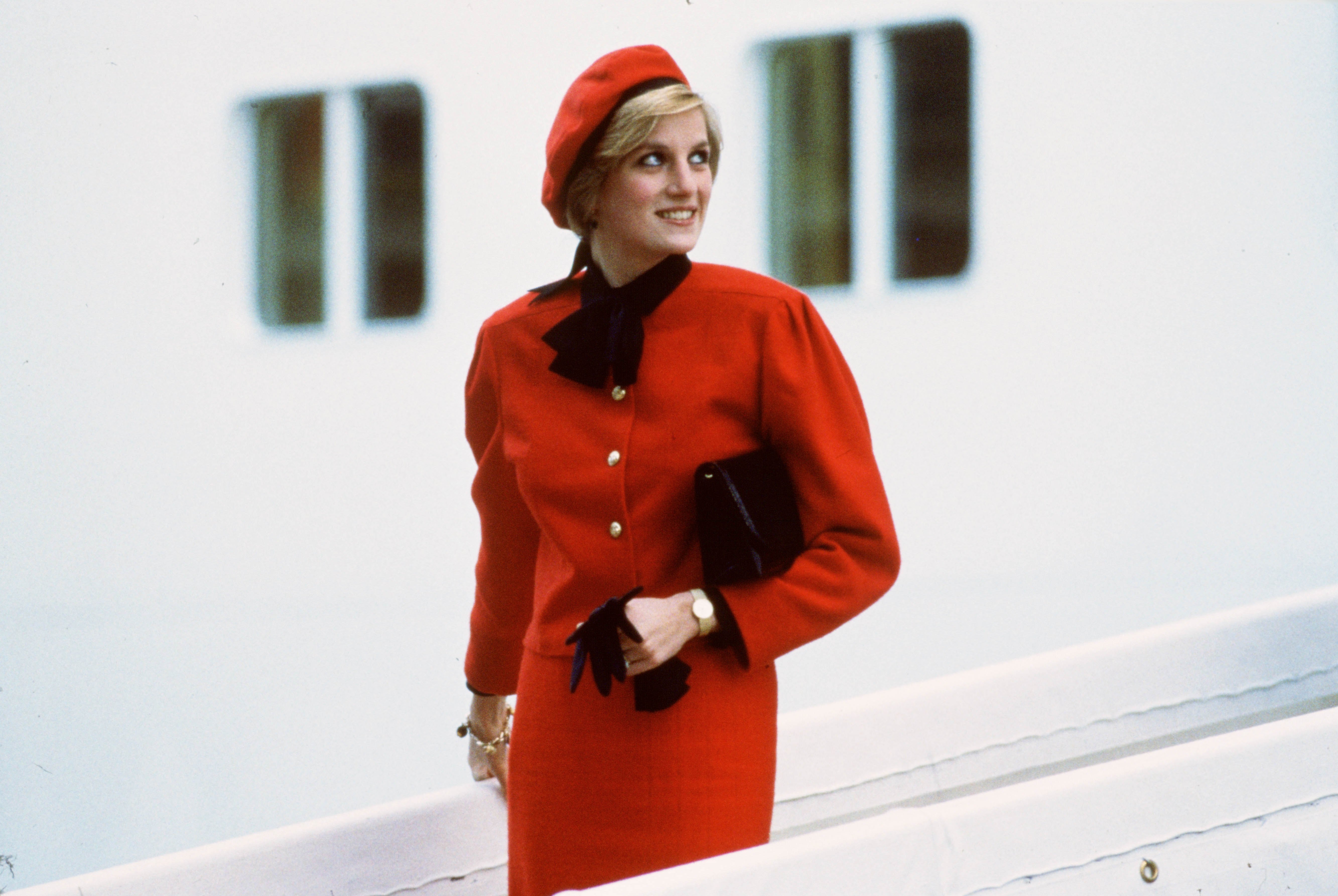 Princess Diana wearing a charm bracelet and red outfit