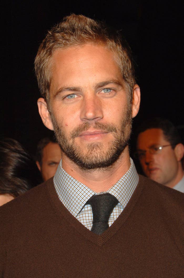 Paul Walker wearing a suit with a checkered shirt and tie, posing at a formal event