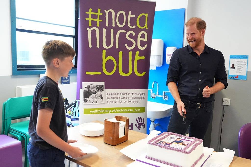 prince harry laughs while cutting cake