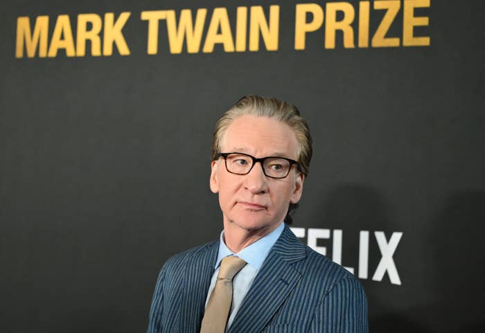 Bill Maher in striped suit and tie at a Mark Twain Prize event backdrop