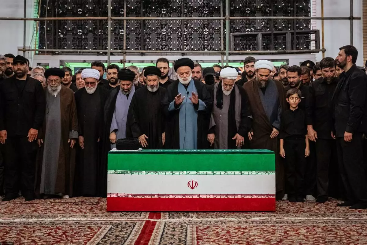 Mostafa Khamenei, center, brother of Iran's new Supreme Leader Mojtaba Khamenei, leads a prayer over the coffin of his late father, Iranian Supreme Leader Ayatollah Ali Khamenei before his burial at the Imam Reza Shrine in Mashhad, northeastern Iran, Thursday, July 9, 2026. (Office of the Iranian Supreme Leader via AP)