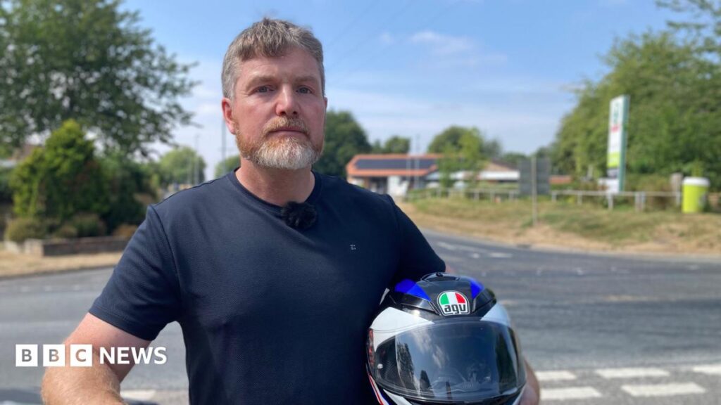Helmets on or off? East Yorkshire bikers split over fuel pump etiquette A woman in a blue puffy jacket looks at the camera. She has brown shoulder length hair and is wearing glasses. Behind her is a pile of red brick rubble and a partly demolished house.
