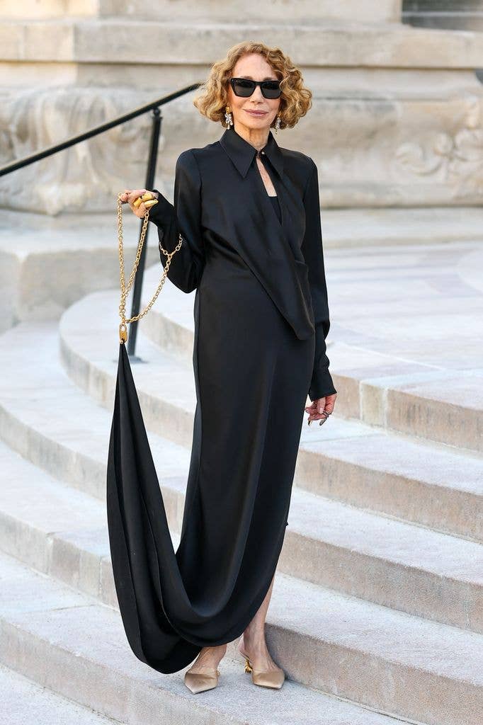 Marisa Berenson wears a long black gown with long sleeves
