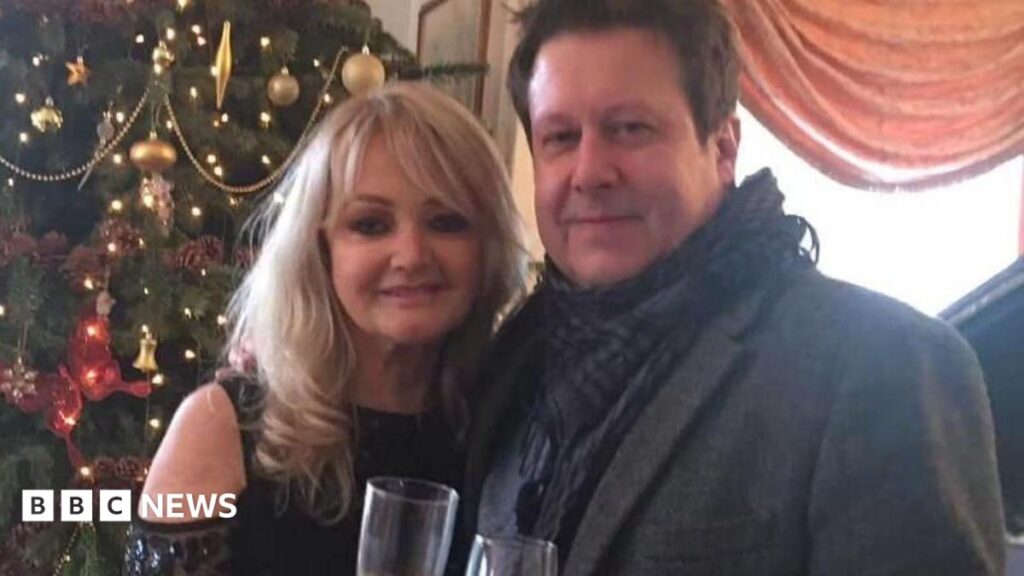 Bonnie Tyler superfan asked for an autograph then spent Christmas at her Mumbles home A glamourous blonde woman wearing a sequined black top, stood with her arm around a brunette man wearing a smartgrey coat and a scarf. They are both holding champaign glasses. Behind them is a Christmas tree decorated with baubles and lights.