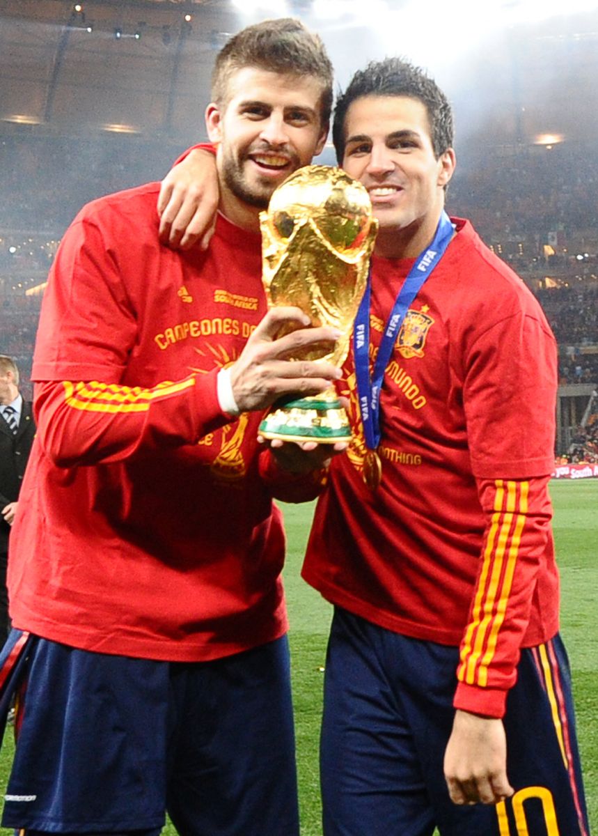 Gerard Pique and Cesc Fabregas pose with the trophy as they celebrate winning the 2010 World Cup football 