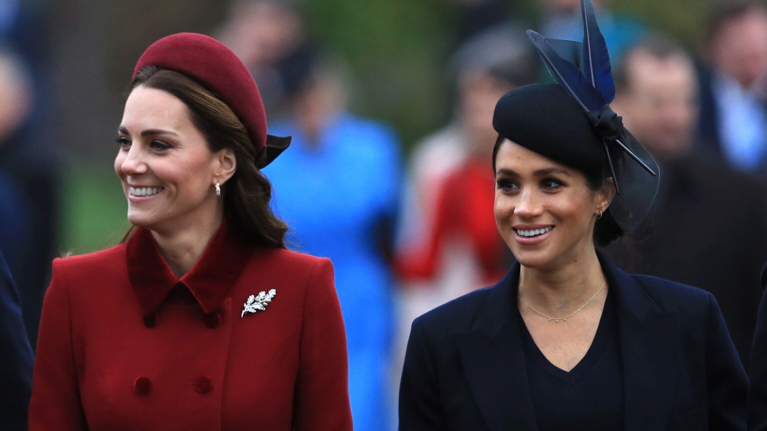 Princess Diana Brought This Quality to the Royal Family, Per Expert Kate Middleton wears a dark red coat and matching hat while Meghan Markle wears a navy coat and matching hat