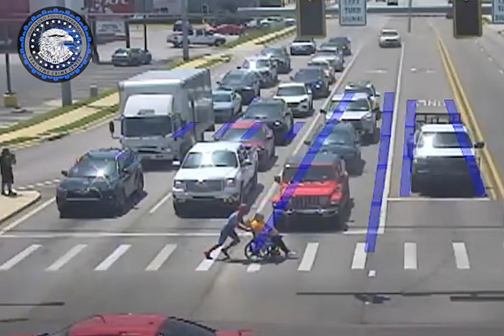 Spider-Man superhero helps a man in a wheelchair cross a busy street.