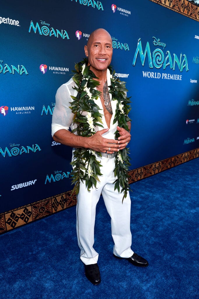 Dwayne Johnson wearing a sheer white shirt and ivory trousers at Disney's Moana world premiere.