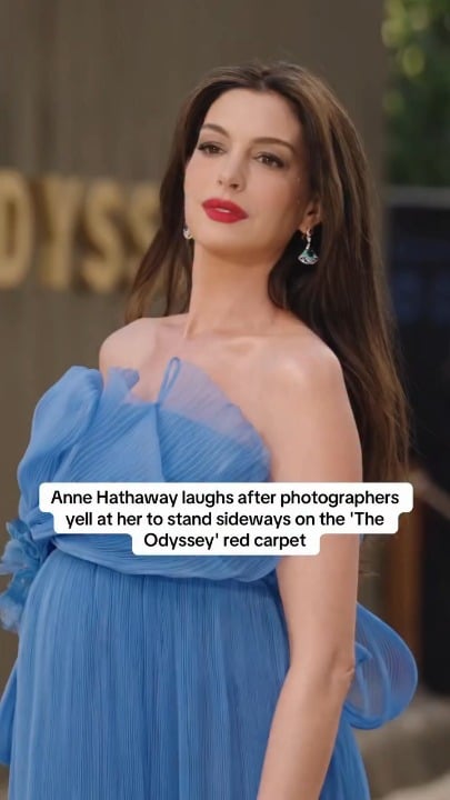 Anne Hathaway laughs after photographers ask her to stand sideways on the ‘The Odyssey’ red carpet, joking, “When you ask like that, of course.”
