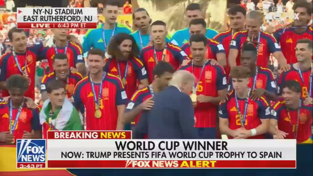 Trump hands the World Cup trophy to Spain, then refuses to get off stage, despite Gianni Infantino trying to direct him off it