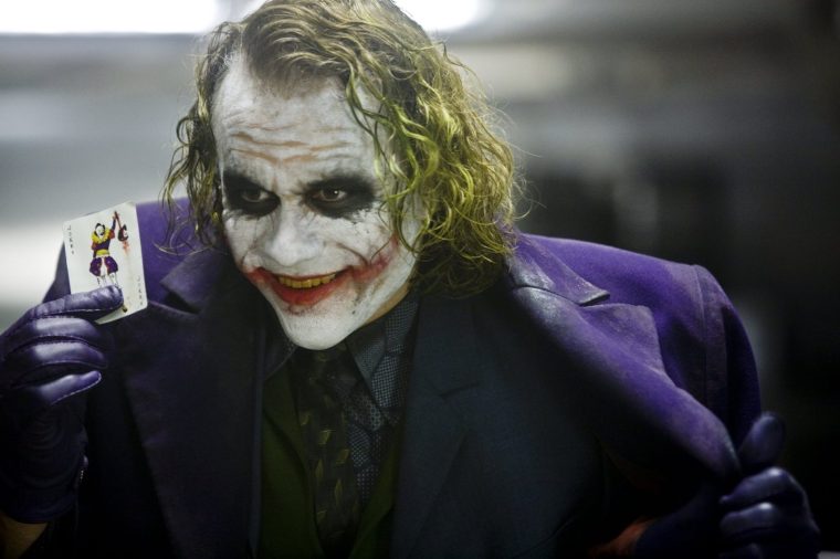 The Dark Knight - Medium shot of Heath Ledger as Joker holding card. The Dark Knight Film still Image from pxl.sky.com