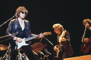 American singer, songwriter and musician Bob Dylan performs live on stage with his band, including bass guitarist Jerry Scheff and guitarist Steven Soles, during the 'Picnic' festival at Blackbushe Aerodrome in Hampshire near Camberley, Surrey, England on 15th May 1978. (Photo by David Redfern/Redferns)