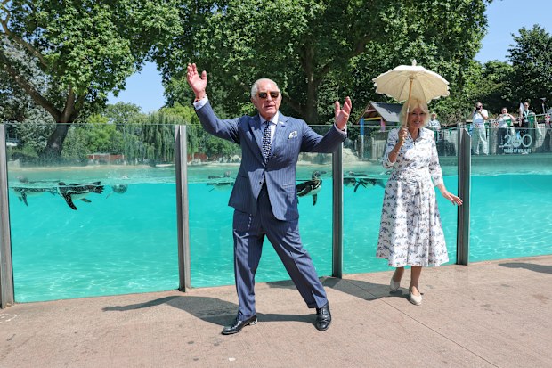 King Charles III and Queen Camilla acknowledge the cheers from a crowd at the Penguin beach at ZSL London Zoo