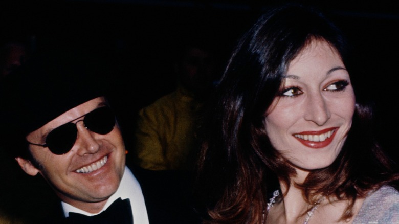 Anjelica Houston smiling at the 1975 Oscars alongside Jack Nicholson