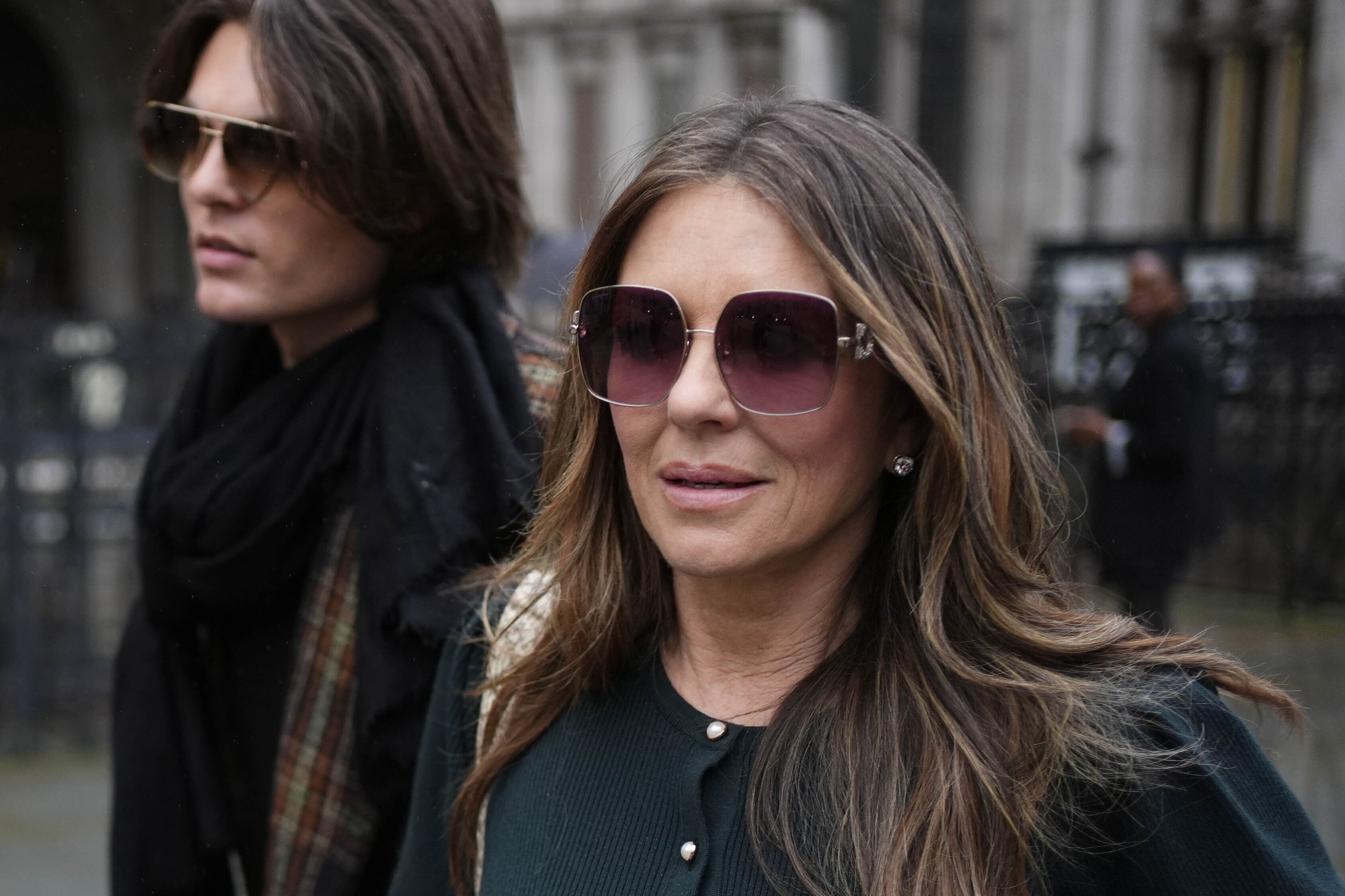 Elizabeth Hurley leaving the Royal Courts of Justice with her son Damian during the trial (Jordan Pettitt/PA)