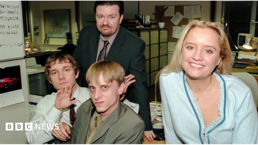 Actors from The Office reflect on UK sitcom’s 25-year anniversary Four people (The Office UK actors) in an office all looking into the camera