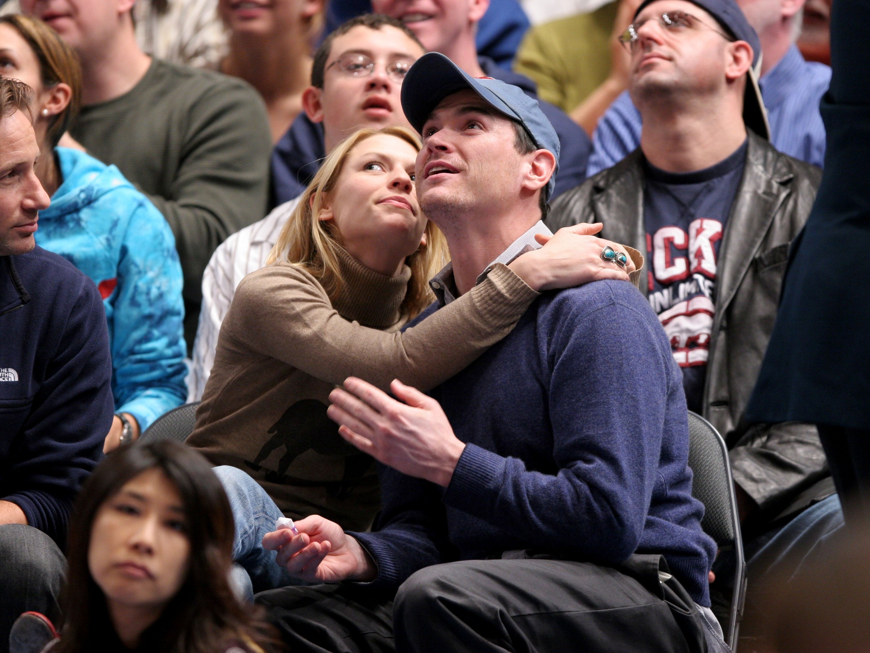 Claire Danes embraces Billy Crudup while in a crowd at a sports game