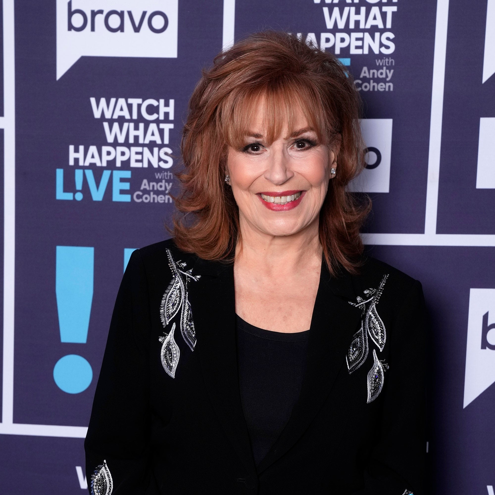 Joy Behar in an elegant, detailed black jacket with floral embroidery, smiling at a 