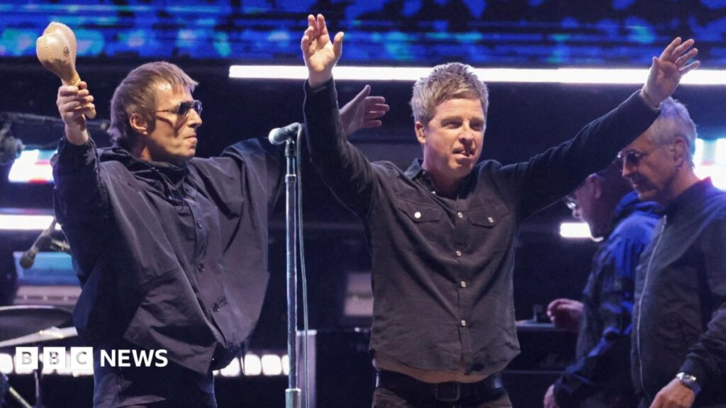 Liam Gallagher and Noel Gallagher of Oasis receive the applause of fans while on stage together at the Rose Bowl Stadium in Pasadena, California in September 2025