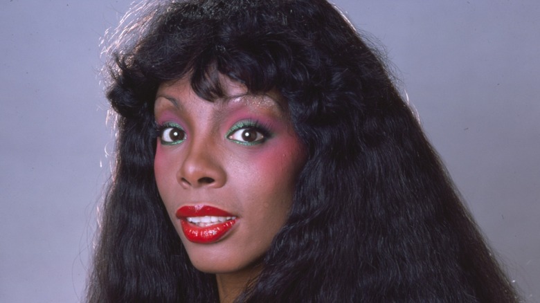 Donna Summer during a 1978 photoshoot wearing green and pink eyeshadow and red lipstick