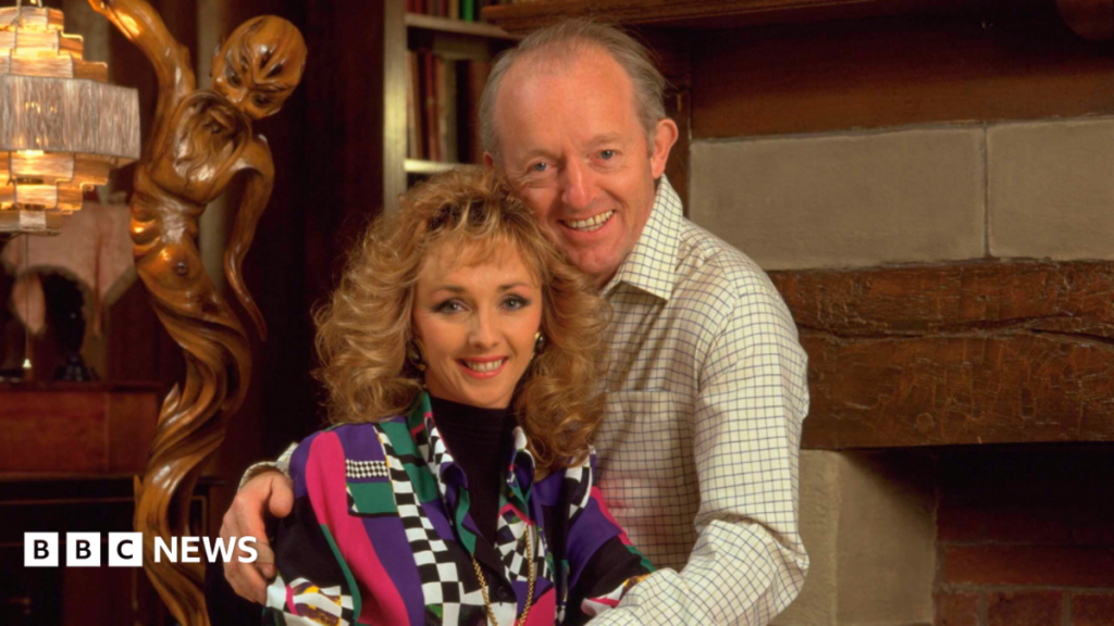 Debbie McGee raises brain tumour awareness after husband’s death Debbie McGee, wearing a colourful outfit, with her late husband Paul Daniels in 1992. They are sat close to each other and Paul has his arms around her.