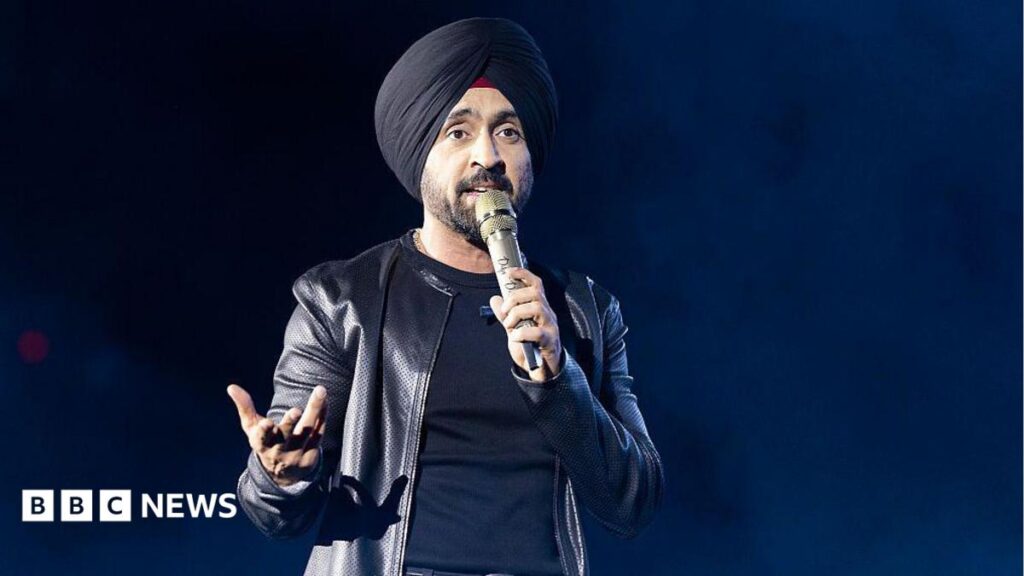 Diljit Dosanjh: Why Satluj was taken off streaming two days after release Diljit Dosanjh kicks off his Aura World Tour at BC Place on April 23, 2026, in Vancouver, British Columbia, Canada. He is wearing a black jacket over a black t-shirt and sporting a black turban, as he speaks on a microphone from the stage.