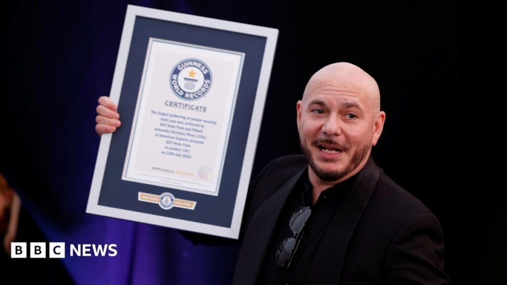 Pitbull fans set Guinness World Record at BST Hyde Park show Pitbull wears a dark suit jacket over a dark shirt. He is holding a Guinness World Record award.