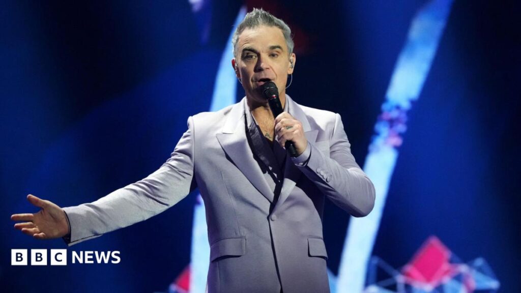 British Singer songwriter Robbie Williams performs on stage during the draw for the 2026 FIFA Football World Cup taking place in the US, Canada and Mexico, at the Kennedy Center, in Washington, DC, on December 5, 2025