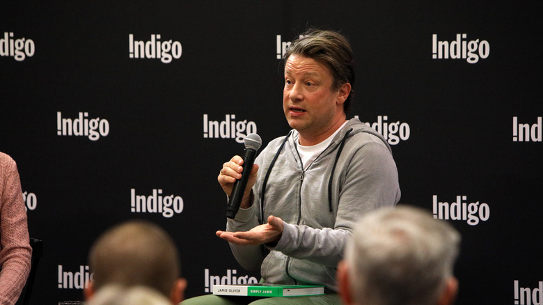 Seated Jamie Oliver speaks to an audience