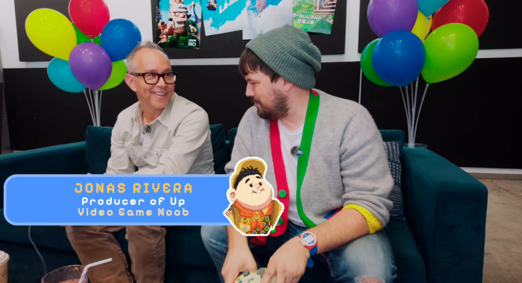 ‘Up’ Movie Producer Plays 2009 ‘Up’ Video Game for First Time Jonas Rivera sits on a couch in front of multicolored balloons.