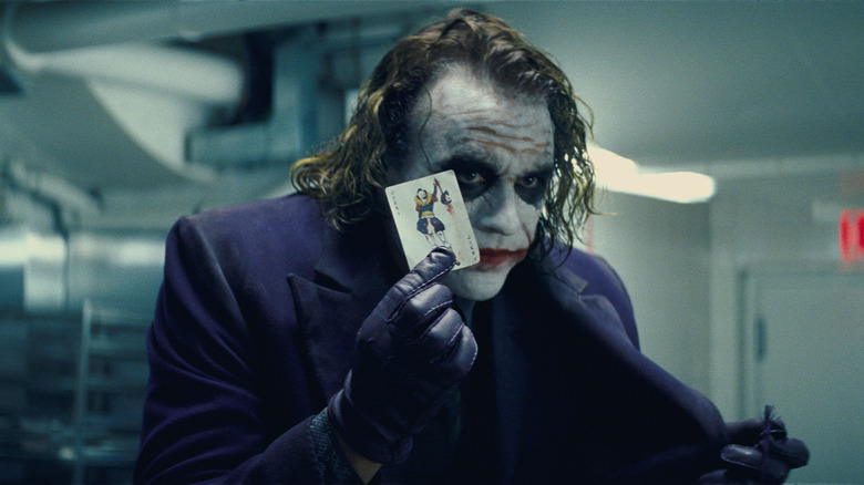 The Joker holding a playing card in The Dark Knight