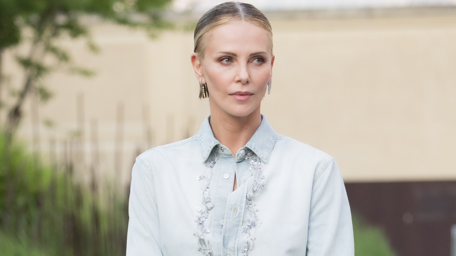Charlize Theron Styled Ankle Boots With a Summery Dior Outfit Charlize Theron styled surprising ankle boots from Dior with a denim button-down and black mini skirt
