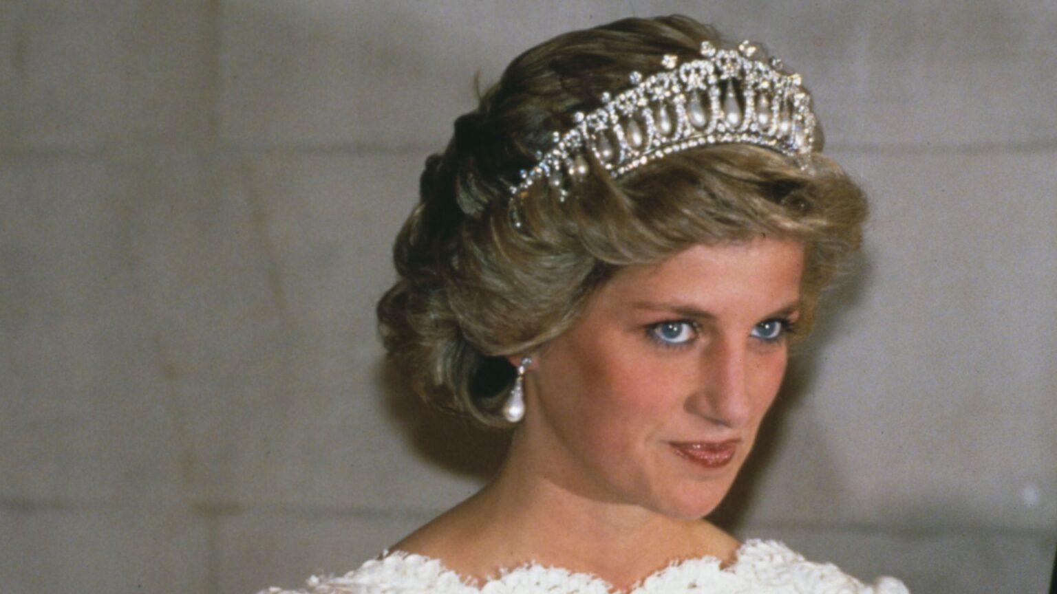 Princess Diana wearing a white evening dress and the Queen Mary tiara at a visit to the British Embassy in Washington with Prince Charles on November 11th, 1985