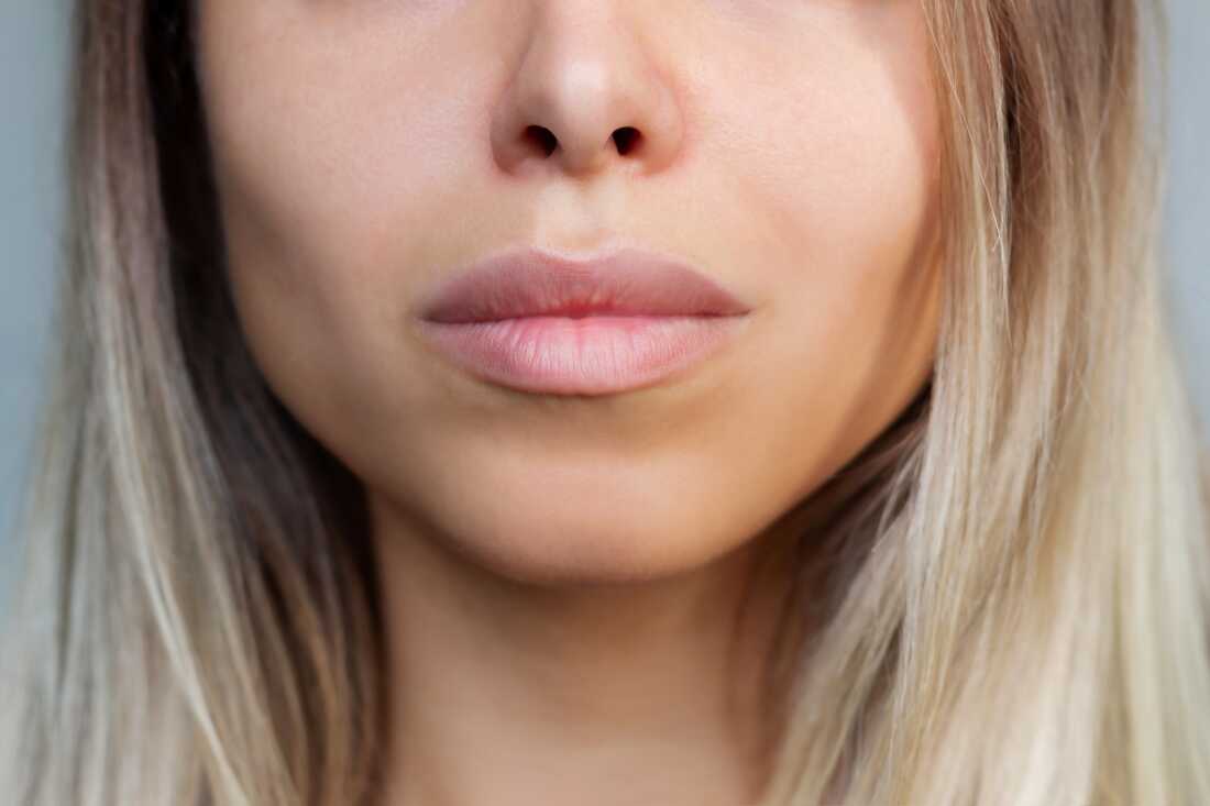 A close up of a blonde woman's nose and lips.
