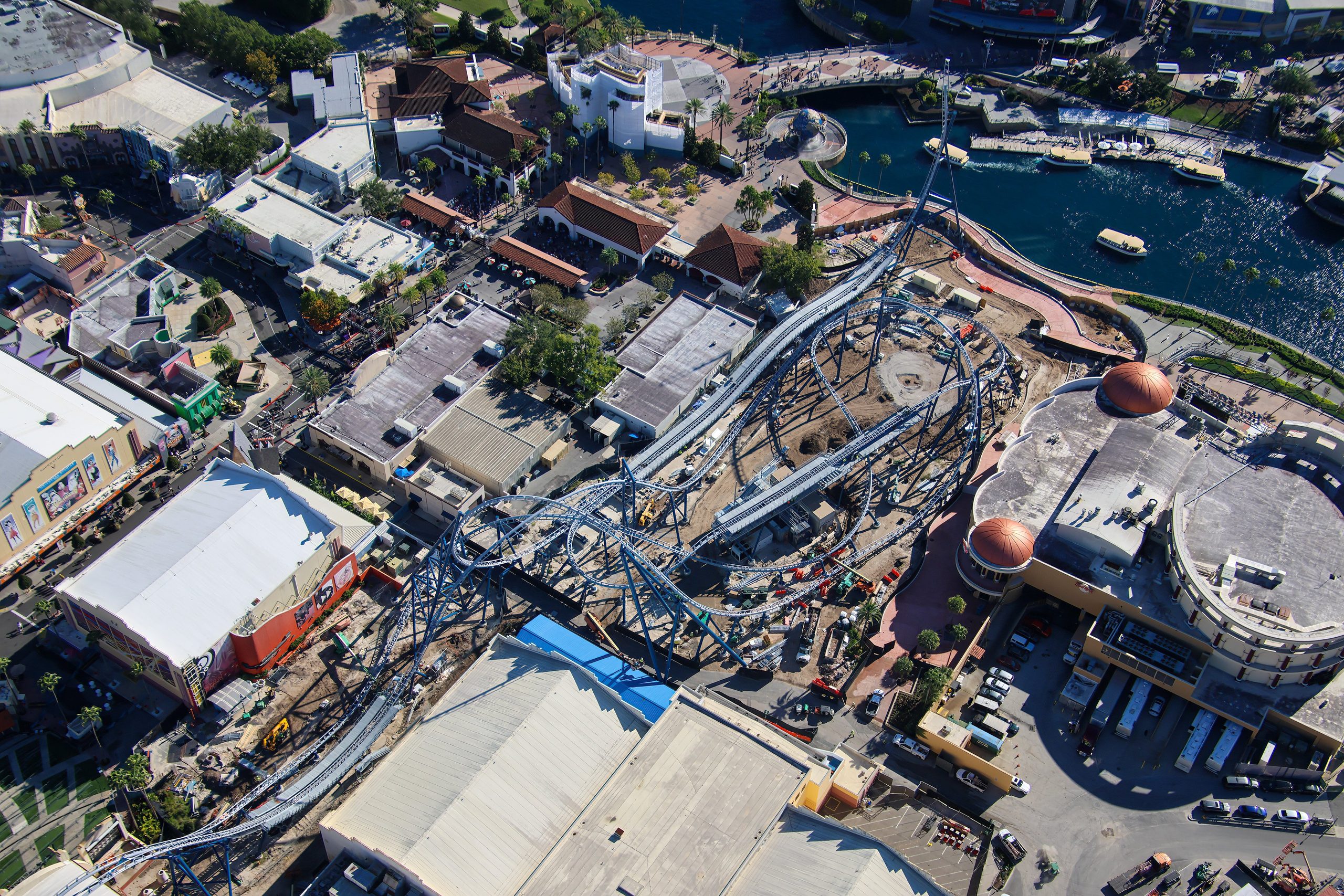 Crews are fine-tuning track components and completing waterfront pavement around Fast & Furious: Hollywood Drift at Universal Studios Florida, as new photos offer a closer look inside the coaster’s station and surrounding construction site.