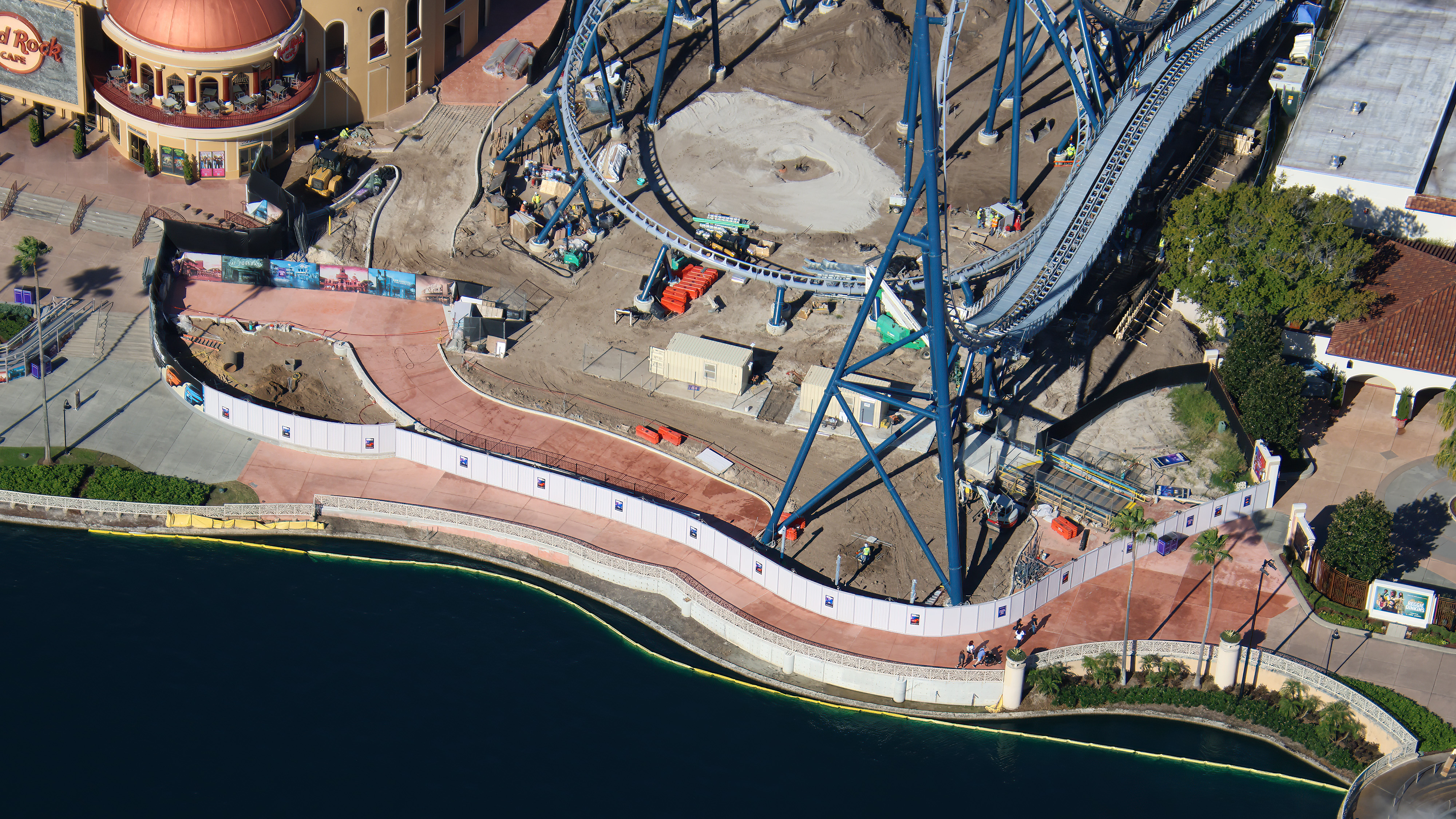 Crews are fine-tuning track components and completing waterfront pavement around Fast & Furious: Hollywood Drift at Universal Studios Florida, as new photos offer a closer look inside the coaster’s station and surrounding construction site.