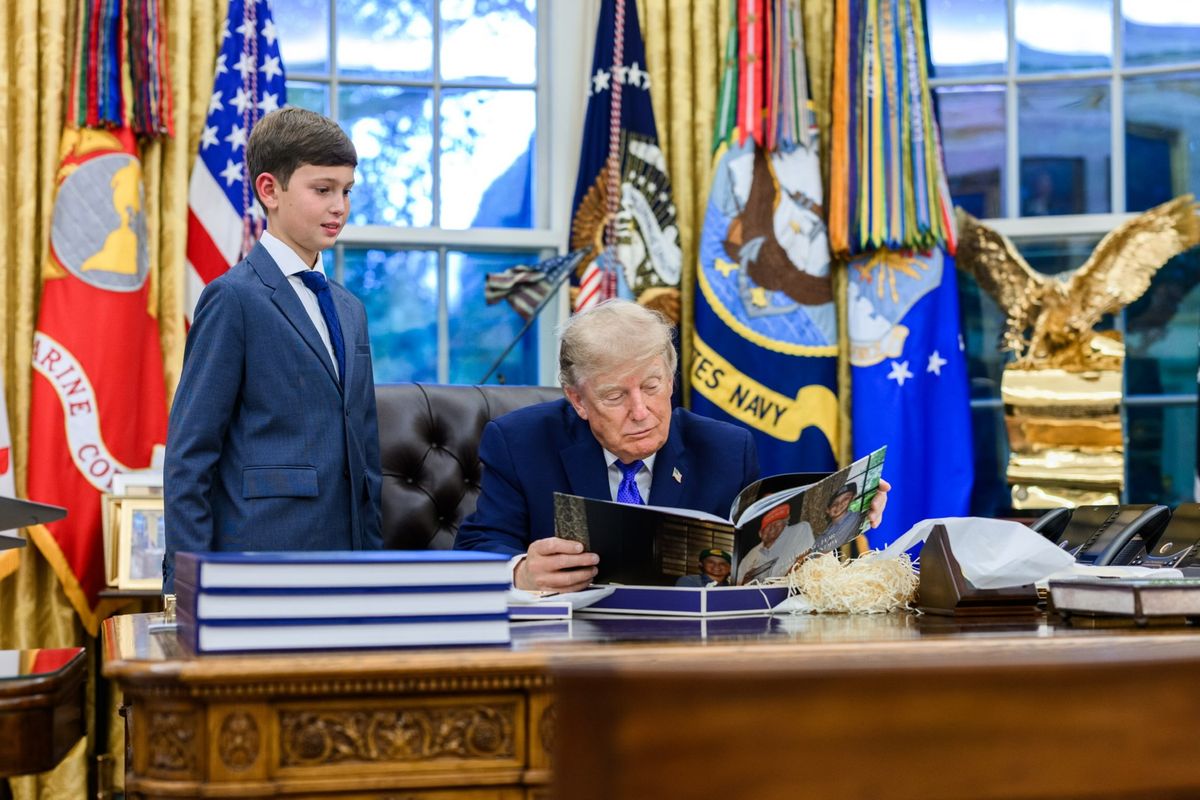 Donald Trump looked through a photo book while spending time with his grandson Joseph inside the Oval Office.